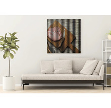 Wohnzimmer mit Dekoration: Wandbild mit Holzstruktur und Wurstmotiv über einem Sofa.