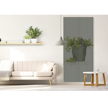 Wohnzimmer mit Sofa, Tisch und Wanddekoration mit Pflanzenmotiv hinter schwarzen Streifen