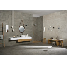 Badezimmer mit grauen Fliesen, Waschtisch mit rundem Spiegel und Holzelementen, Holzbank und Dekoartikel