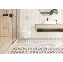 Badezimmer mit Dusche, Toilette, Waschtisch und Bodenfliesen mit Muster