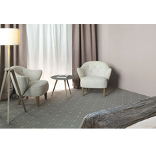 Zwei Sessel und ein runder Tisch stehen in einem hellen Raum mit Vorhängen und einer Stehlampe.