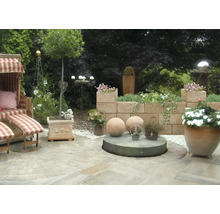 Gestalteter Gartenbereich mit Strandkorb, Mauer und Pflanzgefäßen.