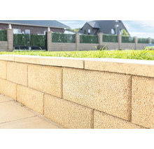 Nahaufnahme einer Gartenmauer aus Betonsteinen mit Abdeckung.