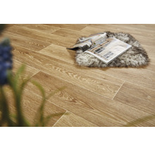 Verlegter Boden mit Holzoptik, darauf Zeitschrift und Fellteppich