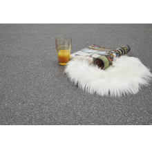 Szene mit Glas Orangensaft, Zeitschrift und Schaffellteppich