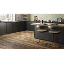 Moderne Küche mit dunklen Schränken, einer Kochinsel und Holzboden.