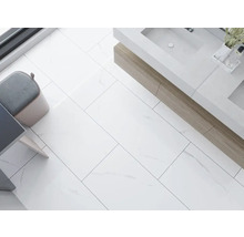 Helles Badezimmer mit rechteckigen Bodenfliesen, Waschtisch und Hocker.