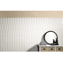 Badezimmer mit weißen, länglichen Fliesen an der Wand und einem Waschtisch mit Spiegel