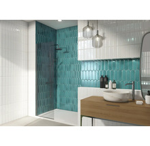 Badezimmer mit Dusche, Waschbecken und Wandfliesen in verschiedenen Formen