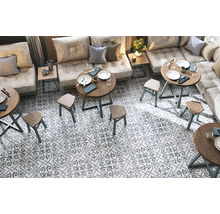 Innenraum mit Sitzbereich, Tischen und gemusterten Fliesen