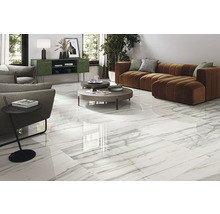 Helles Wohnzimmer mit weißen Fliesen in Marmoroptik, Sofa und Beistelltisch.