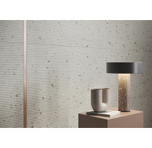 Nahaufnahme von strukturierten Wandfliesen mit horizontalen Linien und dekorativen Elementen in einem Innenraum