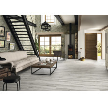 Heller Wohnraum mit Steintreppe, Sofa, Holztisch, Kaminofen und Holzbodenfliesen in Holzoptik.