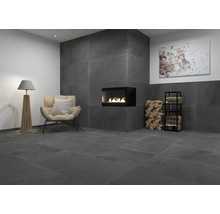 Wohnzimmer mit anthrazitfarbenen Fliesen, Kamin, Sessel und Stehlampe