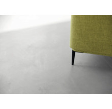 Detailansicht eines grünen Sofas mit schwarzen Füßen.