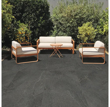 Terrasse mit Sitzgruppe und dunklen Bodenfliesen im Außenbereich.