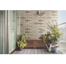 Balkon mit Steinwand, Holzboden und Pflanzen