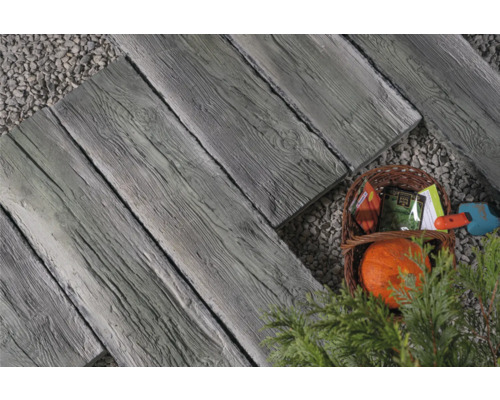 Gartenweg aus Betonplatten in Holzoptik mit Korb und Gartenzubehör