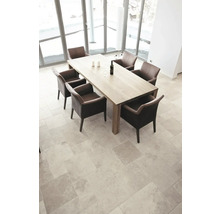 Heller Raum mit Esstisch und Stühlen auf Fliesenboden