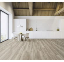 Heller Raum mit Holzbalkendecke, weißer Küchenzeile, Esstisch und hellem Holzfußboden