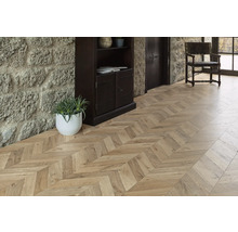 Innenraum mit hellbraunem Holzboden im Fischgrätenmuster, Steinwand und dunklem Holzregal