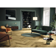 Wohnzimmer mit Parkettboden im Fischgrätmuster, Sofa, Sessel und Dekoration