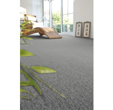 Wohnzimmer mit grauer Auslegeware, Rattanliege und geöffneter Tür