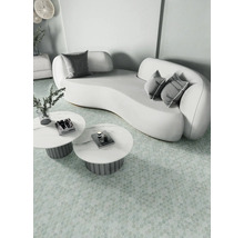 Helle Szene mit geschwungenem Sofa, Kissen und runden Tischen auf gemustertem Boden