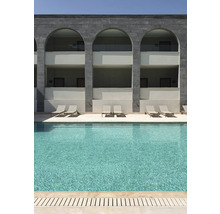 Schwimmbad mit Liegestühlen vor einem Gebäude mit Bögen