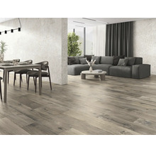 Heller Wohnraum mit Holzboden, Esstisch und grauer Couch