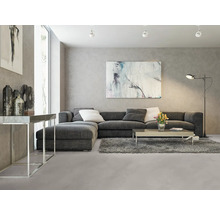 Wohnzimmer mit grauer Eckcouch, Couchtisch, Stehlampe und Kunstwerken an der Wand.