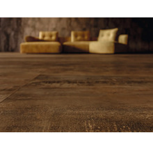 Nahaufnahme von dunkelbraunem Bodenbelag mit Couch im Hintergrund