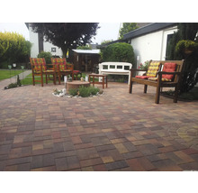 Gepflasterter Gartenbereich mit Gartenmöbeln und Dekorationen.