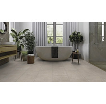 Badezimmer mit freistehender Badewanne, Waschtisch, Pflanzen und Fliesenboden für ein helles und freundliches Ambiente.