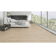 Heller Schlafbereich mit Laminatboden, Bett und großem Fenster mit Ausblick auf die Natur.