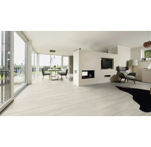 Heller Wohnraum mit Holzboden, Esstisch und Stühlen sowie einer Sitzecke mit Sessel