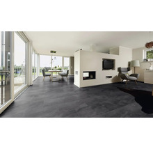 Heller Wohnraum mit Esstisch, Stühlen, Sessel, Fernseher und dunklem Bodenbelag