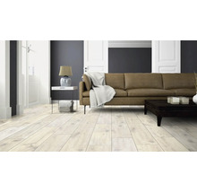 Heller Wohnraum mit Laminatboden, Sofa und Tisch.