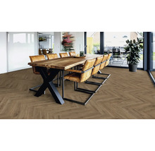 Heller Raum mit Holzboden in Fischgrätmuster und Esstisch mit Stühlen