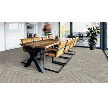 Heller Raum mit Esstischgruppe und verlegtem Vinylboden in Fischgrätmuster.