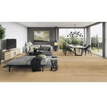 Helles Wohnzimmer mit Couch, Esstisch, Kaminofen und Parkettboden.