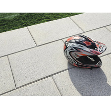 Helle Pflastersteine im Außenbereich mit einem Motorradhelm.