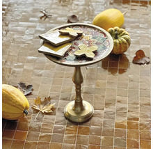 Dekorativer Tisch mit Ornamenten, Kürbissen und Herbstlaub auf gefliestem Untergrund