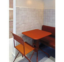 Szene mit einem quadratischen Tisch, einem Stuhl und einer Sitzbank in einer Ecke mit Fliesenwand