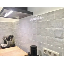 Küchenszene mit Dunstabzugshaube und quadratischen Wandfliesen