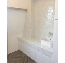 Helles Badezimmer mit Waschbecken, Fliesen und Unterschrank