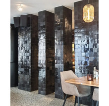 Innenraum mit Säulen verziert mit schwarzen Fliesen, Tisch und Stühlen