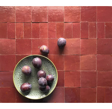 Fliesen mit Teller und Pflaumen