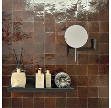 Badezimmer mit quadratischen Fliesen, Ablage mit Dekorationen und Spiegel