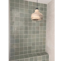 Gefliester Duschbereich mit Sitzbank und Pendelleuchte